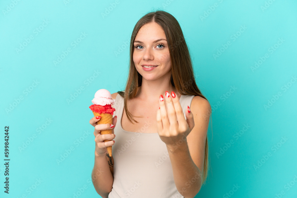 Young Lithuanian woman with cornet ice cream isolated on blue background inviting to come with hand. Happy that you came Young Lithuanian woman with cornet ice cream isolated on blue background inviting to come with hand. Happy that you came