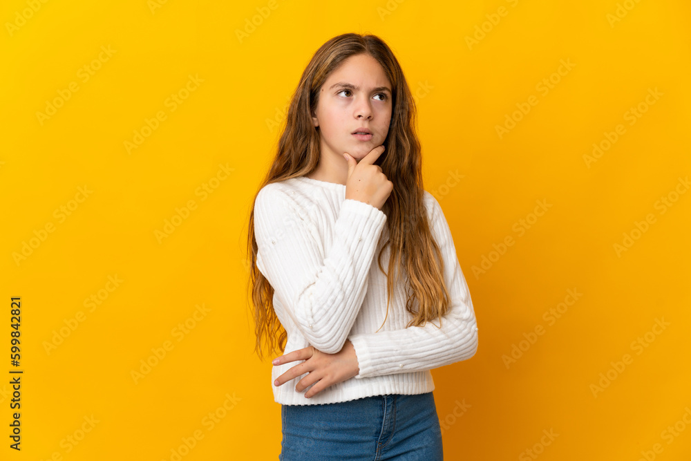 Child over isolated yellow background having doubts Child over isolated yellow background having doubts