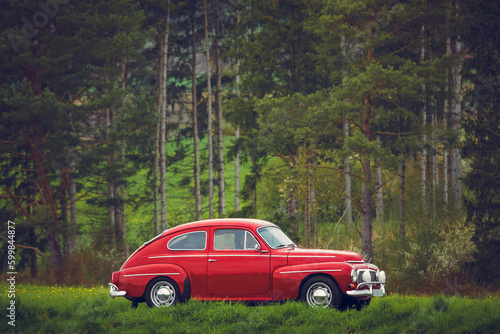 Classic oldtimer vintage two-door car of the 1950s - 1960s on a country road photo