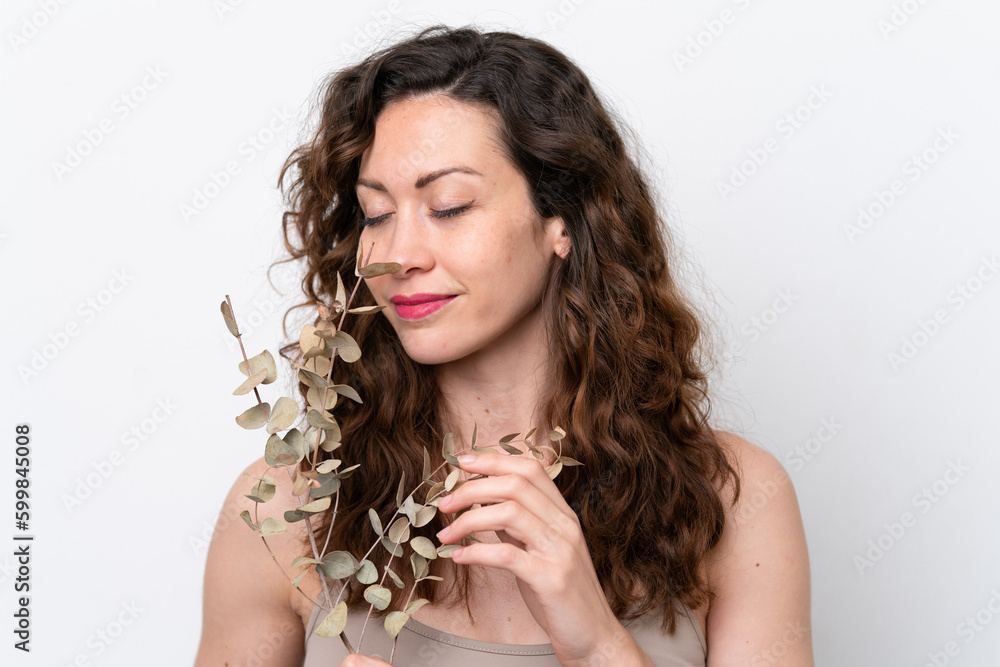 Young caucasian woman isolated on white background holding a eucalyptus branch. Close up portrait