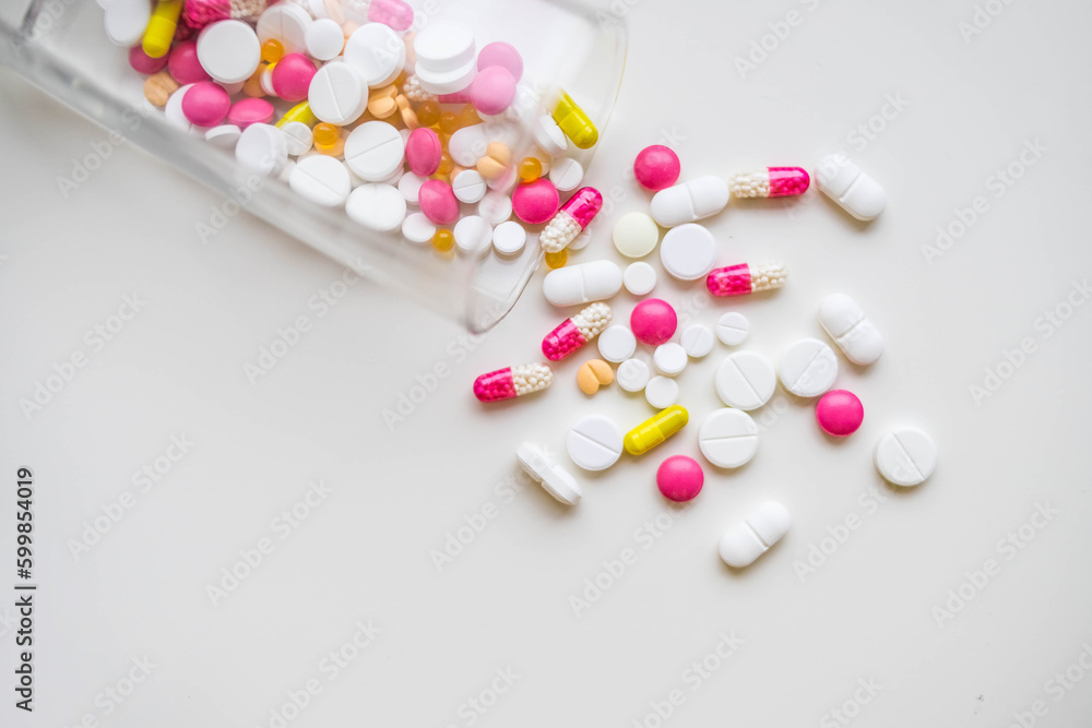 Many colorful tablets spilling out of package, Medicine, medical insurance or pharmacy concept .copy space.Addictive pain relief drug.prescription for treatment medication. Pharmaceutical medicament Many colorful tablets spilling out of package, Medicine, medical insurance or pharmacy concept .copy space.Addictive pain relief drug.prescription for treatment medication. Pharmaceutical medicament