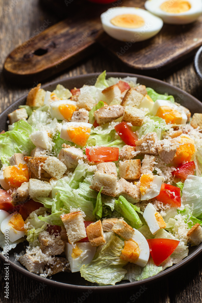 Salad of iceberg leaves, chicken, eggs and tomatoes in a plate. Caesar salad Salad of iceberg leaves, chicken, eggs and tomatoes in a plate. Caesar salad