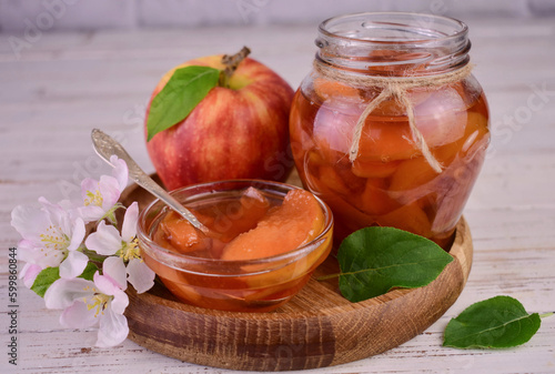 Apple jam in a jar on a wooden tray. 