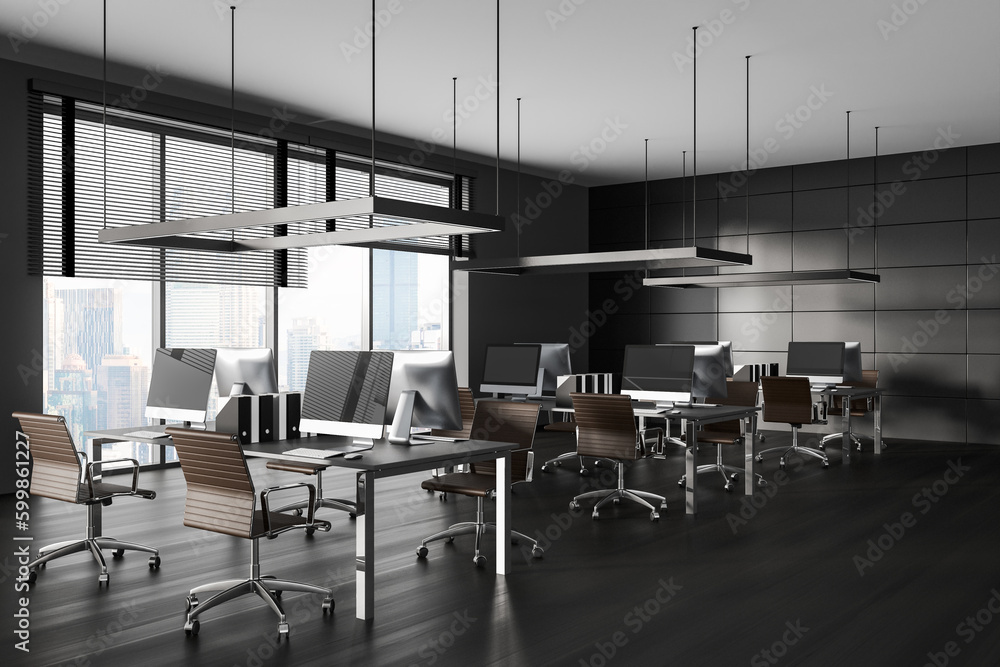 Dark coworking room interior with desk in row, pc computer and panoramic window Dark coworking room interior with desk in row, pc computer and panoramic window