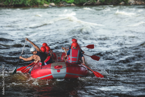 Red raft boat during whitewater rafting extreme water sports on water rapids, kayaking and canoeing on the river, water sports team with a big splash of water