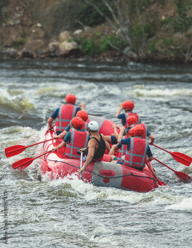 Red raft boat during whitewater rafting extreme water sports on water rapids, kayaking and canoeing on the river, water sports team with a big splash of water
