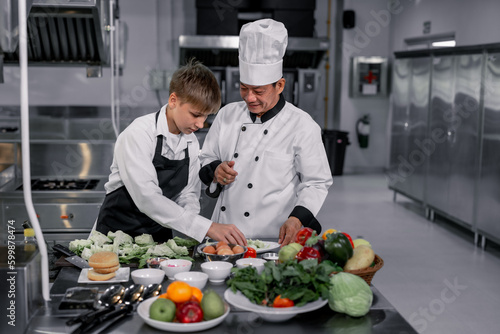 Teenagers learn from expert chefs at culinary school to prepare ingredients and create a variety of tasty meals. A practical activity connected their senses of taste and smell is making hamburgers. photo