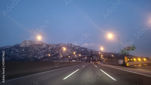 새벽 도로에 가로등과 산