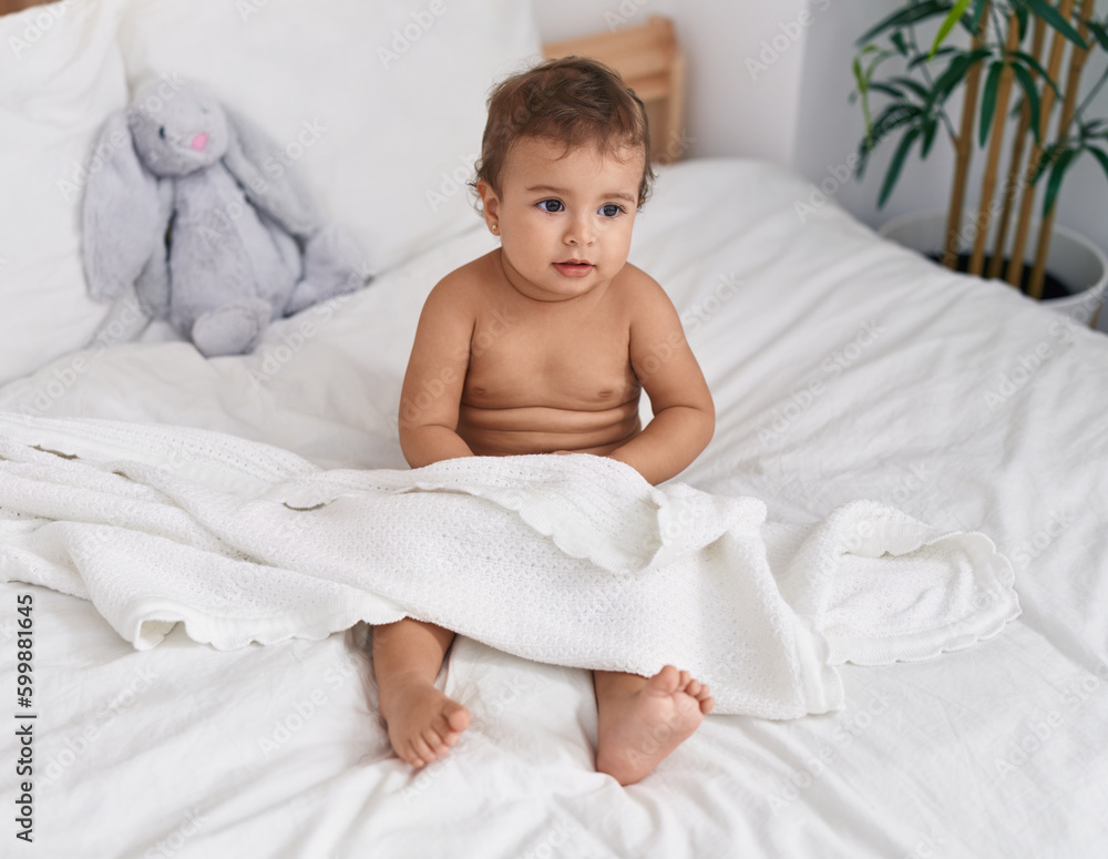Adorable hispanic baby sitting on bed at bedroom Adorable hispanic baby sitting on bed at bedroom