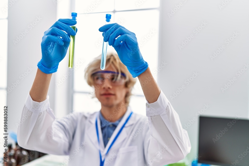 Young blond man scientist holding test tubes at laboratory Young blond man scientist holding test tubes at laboratory