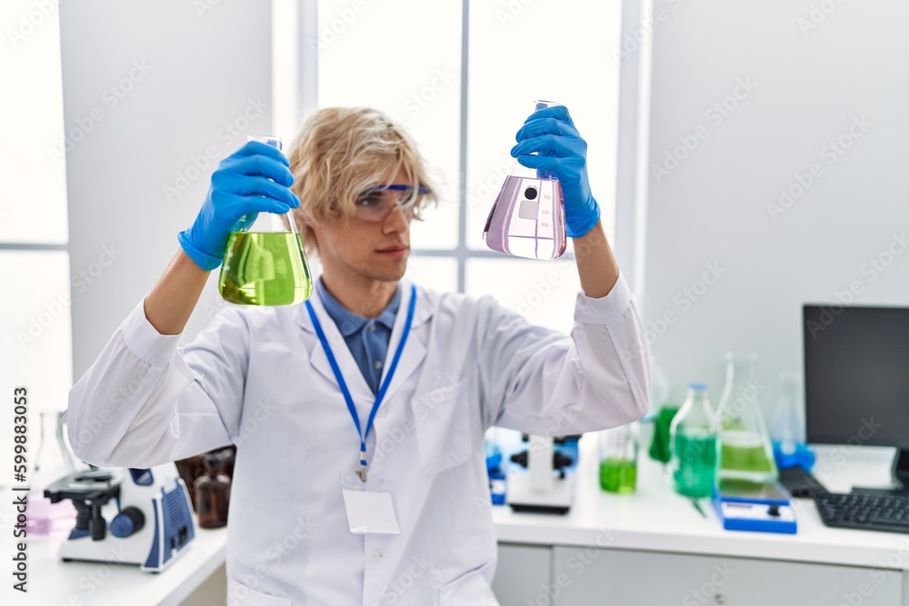 Young blond man scientist holding test tubes at laboratory Young blond man scientist holding test tubes at laboratory