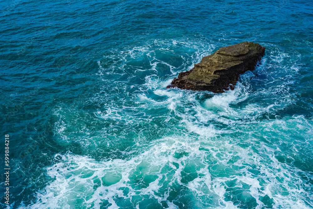 Obraz premium Rock on the ocean with waves surrounding. Pacitan, East Java, Indonesia.