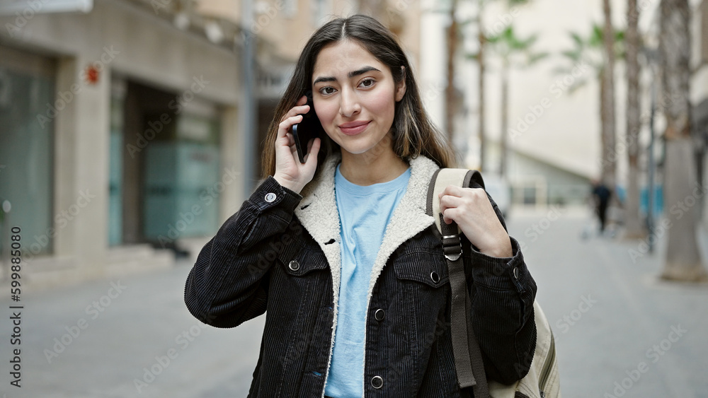 Young beautiful hispanic woman student smiling confident talking on smartphone at street Young beautiful hispanic woman student smiling confident talking on smartphone at street