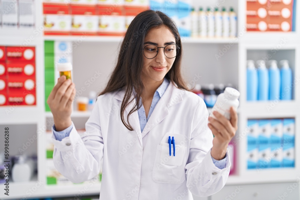 Young hispanic girl pharmacist choosing pills at pharmacy