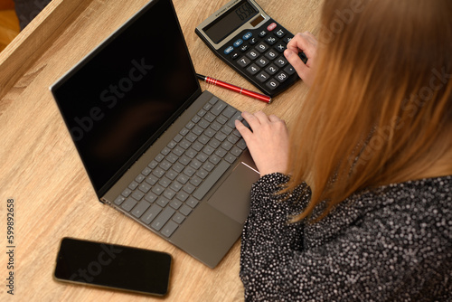 Kobieta siedząca przy biurku przy laptopie