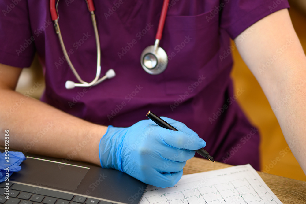 Lekarz siedzący przy biurku ze stetoskopem  - obrazy, fototapety, plakaty 
