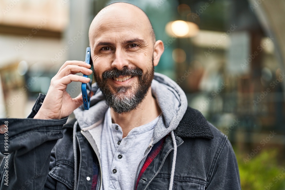 Young bald man smiling confident talking on the smartphone at street Young bald man smiling confident talking on the smartphone at street