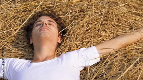 happy man lying in wheat field hay