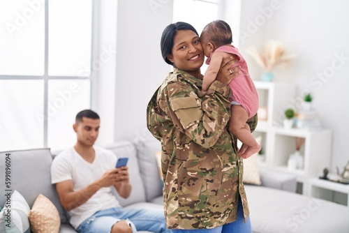 Hispanic family army soldier hugging each other at home