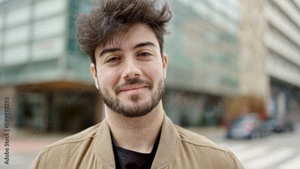 Obraz premium Young hispanic man smiling confident standing at street