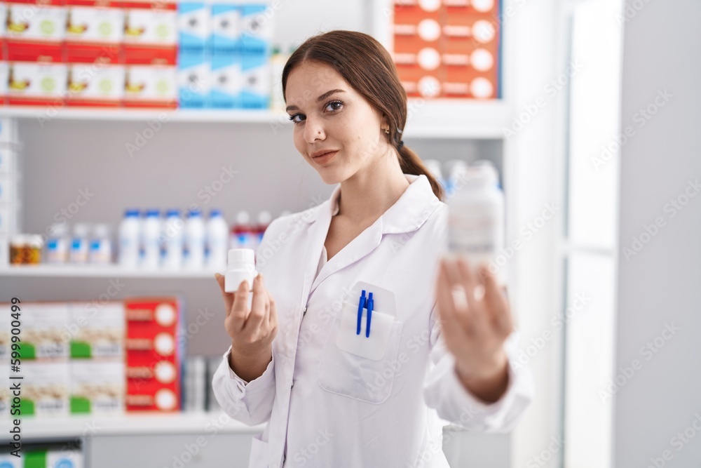 Young woman pharmacist holding pills bottle at pharmacy Young woman pharmacist holding pills bottle at pharmacy