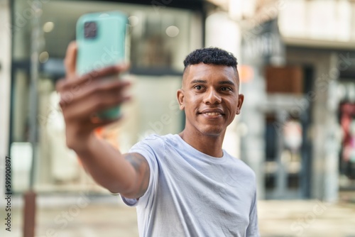 Young latin man smiling confident making selfie by the smartphone at street © Krakenimages.com