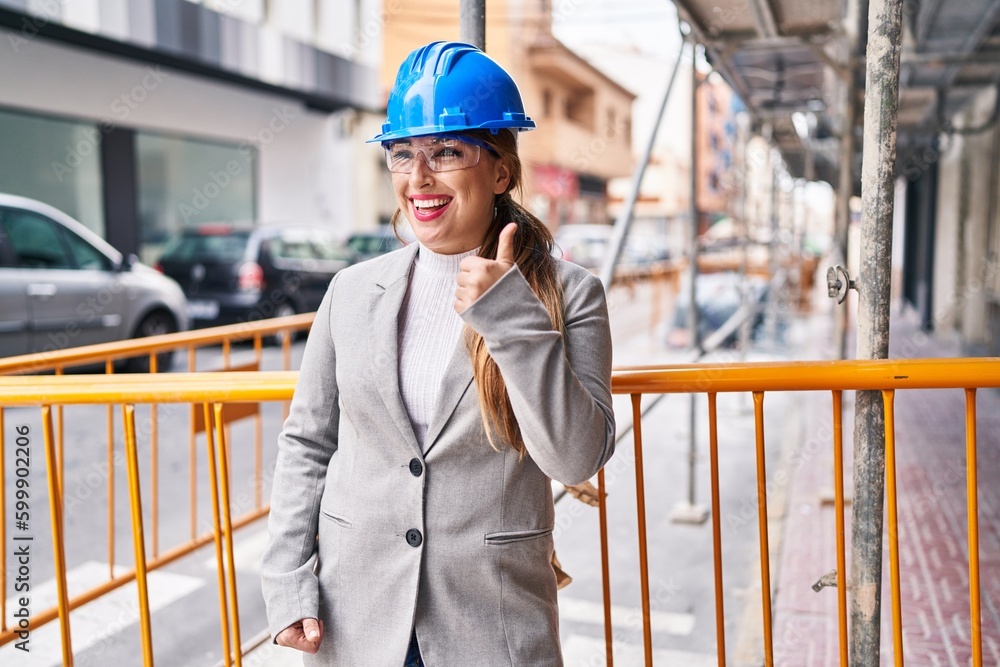 Young beautiful hispanic woman architect smiling confident doing ok gesture at street Young beautiful hispanic woman architect smiling confident doing ok gesture at street