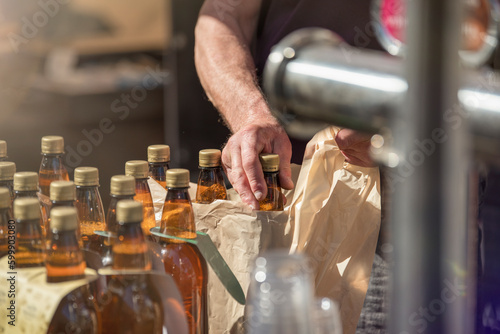 Craft beer vendor packaging beer bottles for a customer. The concept of a small business for the production of beer. Copy space.