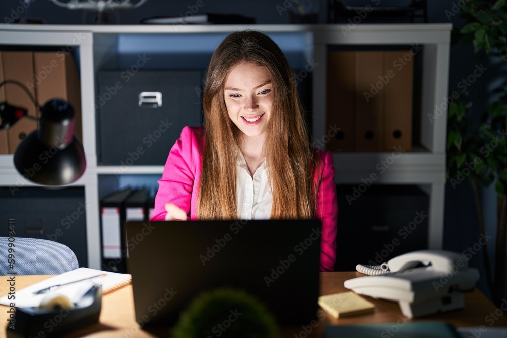 Young caucasian woman working at the office at night smiling friendly offering handshake as greeting and welcoming. successful business. Young caucasian woman working at the office at night smiling friendly offering handshake as greeting and welcoming. successful business.