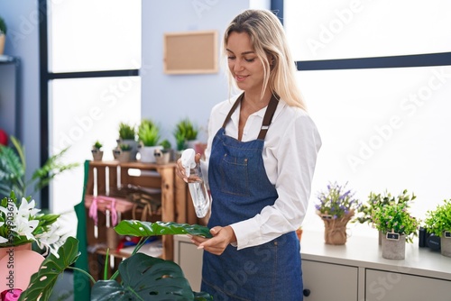 Young blonde woman florist using diffuser working at florist