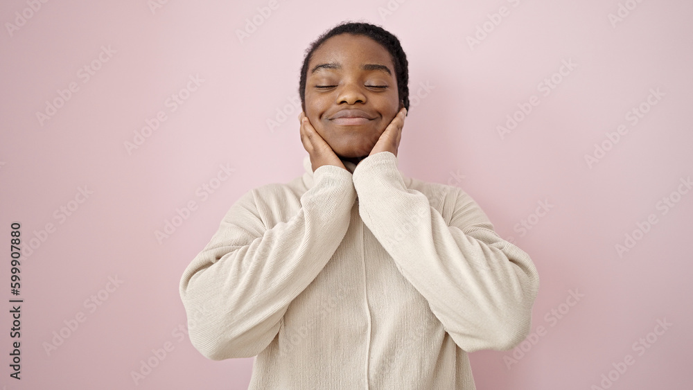 African american woman smiling confident touching face over isolated pink background African american woman smiling confident touching face over isolated pink background