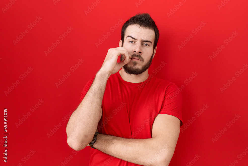 Young hispanic man wearing casual red t shirt mouth and lips shut as zip with fingers. secret and silent, taboo talking Young hispanic man wearing casual red t shirt mouth and lips shut as zip with fingers. secret and silent, taboo talking