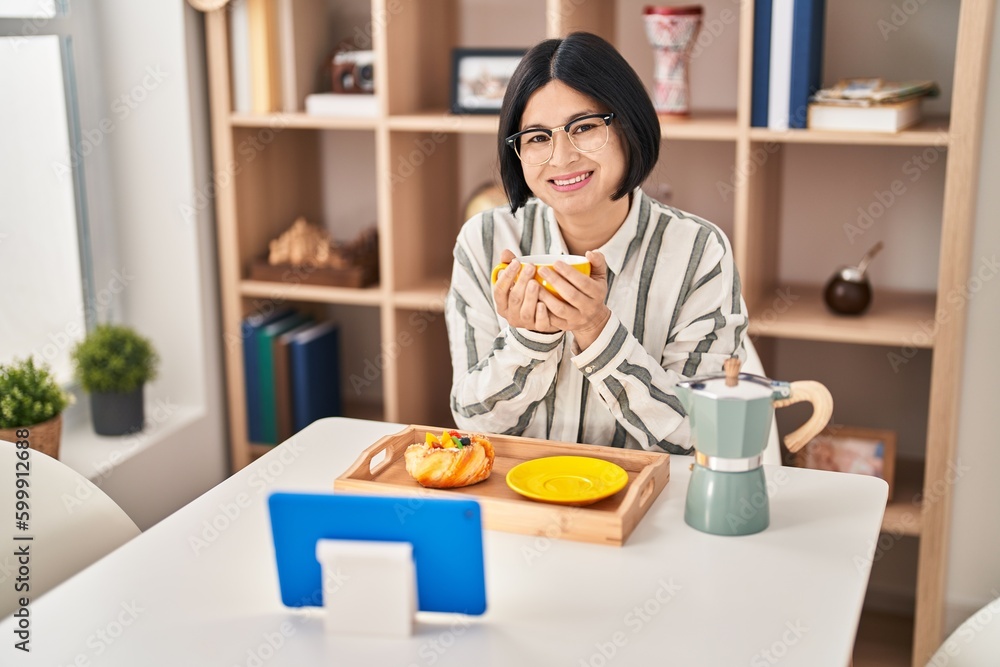 Young chinese woman having breakfast watching movie at home Young chinese woman having breakfast watching movie at home