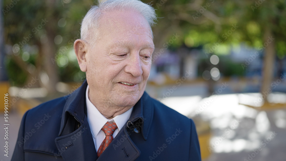 senior standing with serious expression at park senior standing with serious expression at park