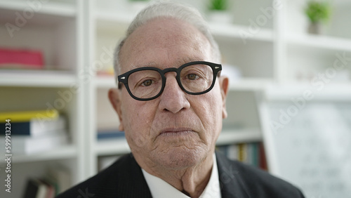 senior standing with serious expression at university classroom