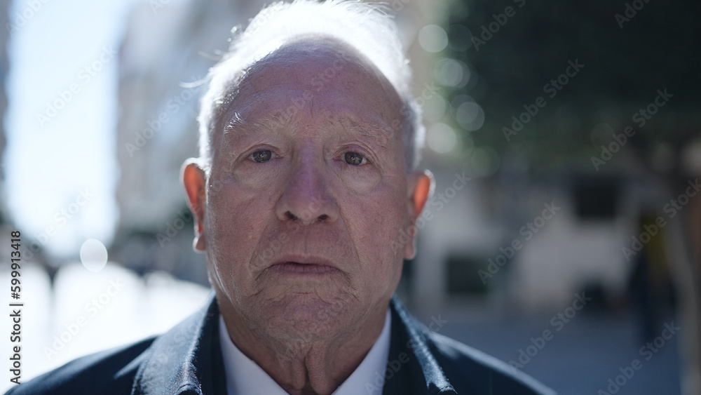 senior standing with serious expression at street senior standing with serious expression at street