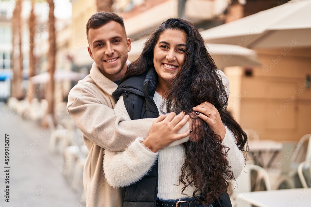 Fototapeta premium Man and woman couple hugging each other standing at street