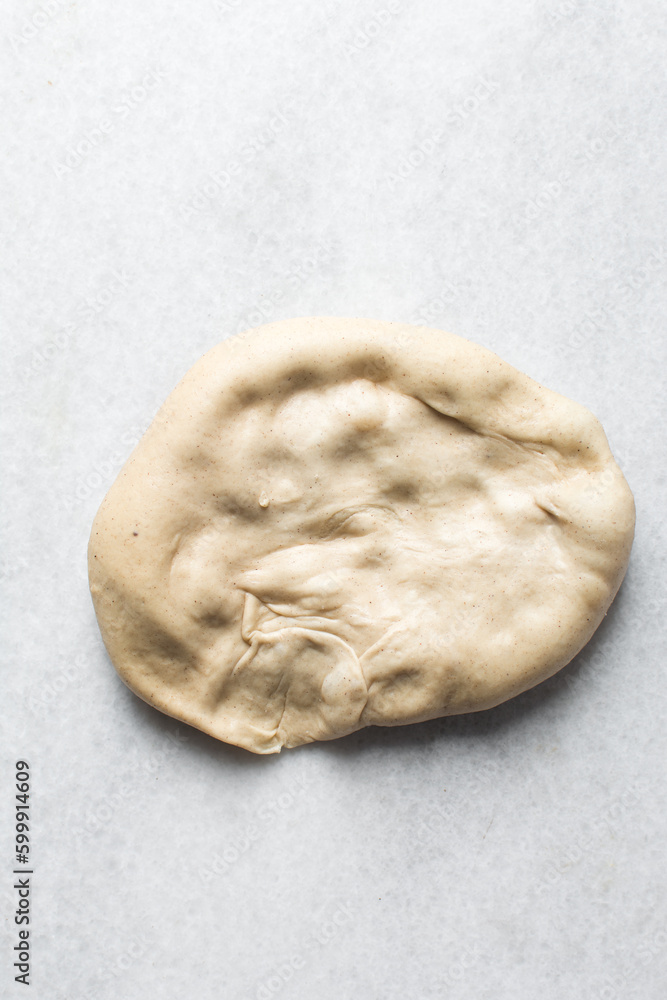 Bread dough resting on a table, Kanelbullar dough or Swedish cinnamon twist dough on a marble surface, process of making Swedish cinnamon buns Bread dough resting on a table, Kanelbullar dough or Swedish cinnamon twist dough on a marble surface, process of making Swedish cinnamon buns
