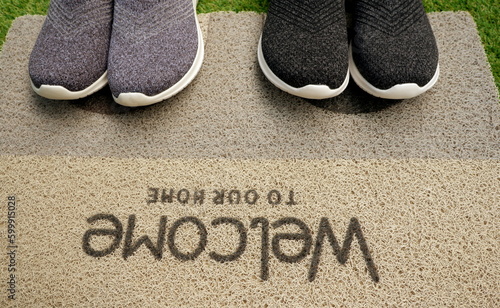pair of shoes on welcome mat on top view