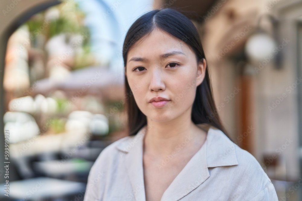 Chinese woman with relaxed expression standing at street