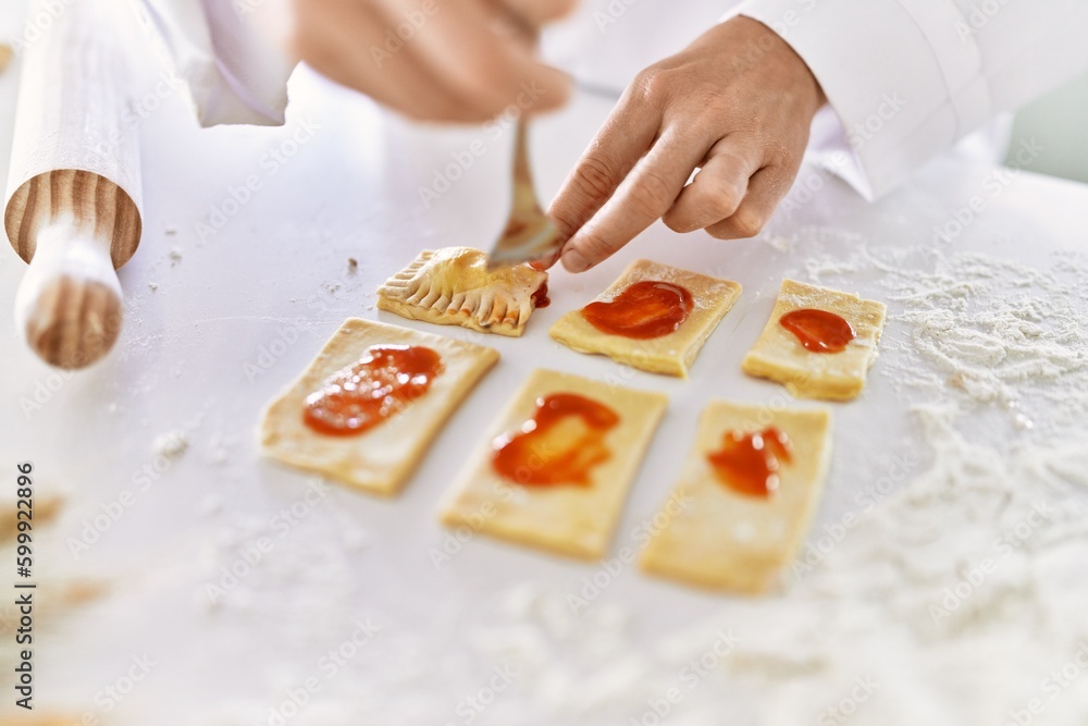 Young woman wearing cook uniform cooking pasta at kitchen Young woman wearing cook uniform cooking pasta at kitchen