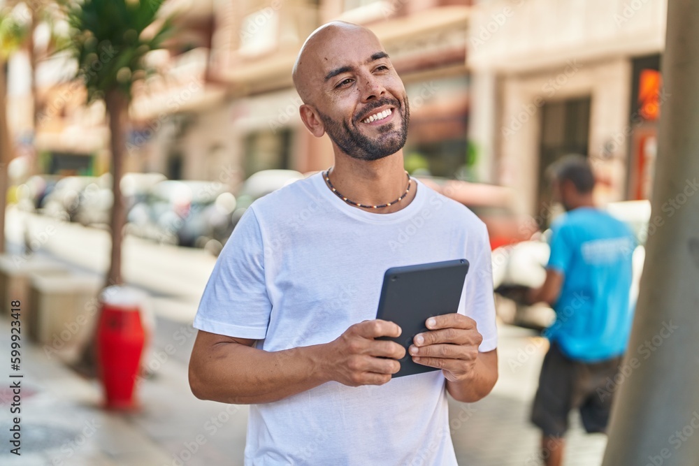 Young bald man smiling confident using touchpad at street Young bald man smiling confident using touchpad at street