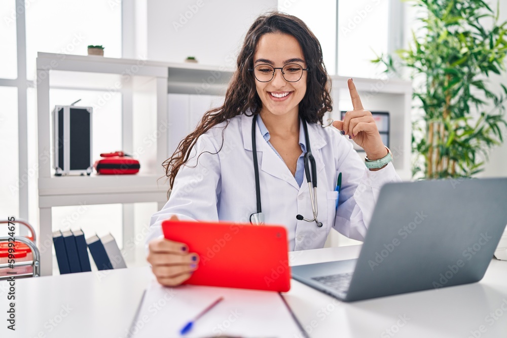Young doctor woman working on online appointment smiling happy pointing with hand and finger to the side Young doctor woman working on online appointment smiling happy pointing with hand and finger to the side