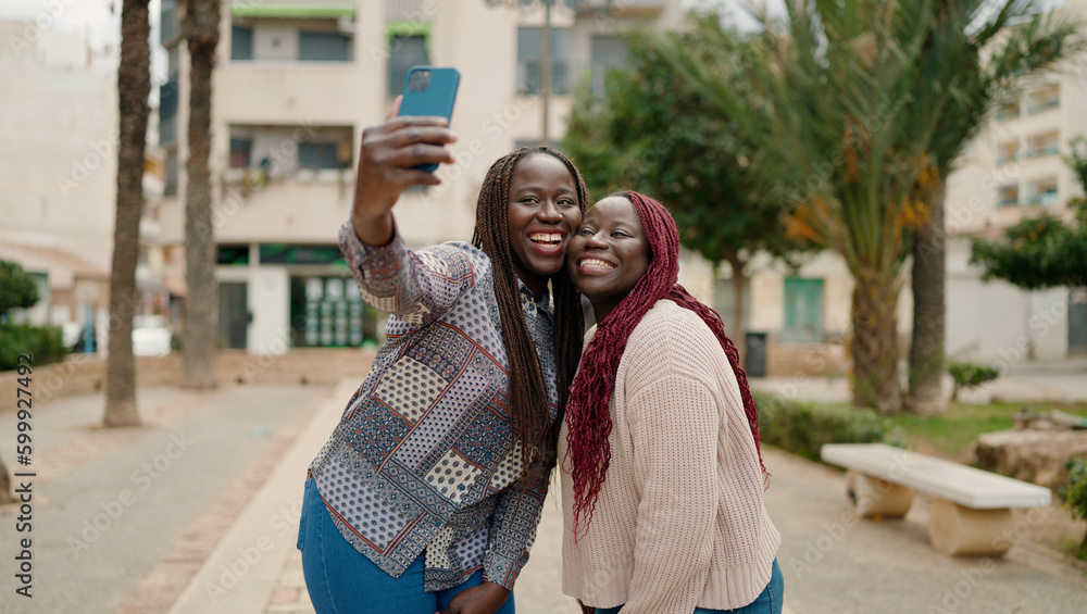 Two african american friends smiling confident making selfie by the smartphone at park