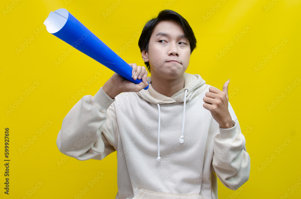 Asian man pointing finger and promoting something while shouting to paper megaphone. best for sale, discount, and promotion content Asian man pointing finger and promoting something while shouting to paper megaphone. best for sale, discount, and promotion content