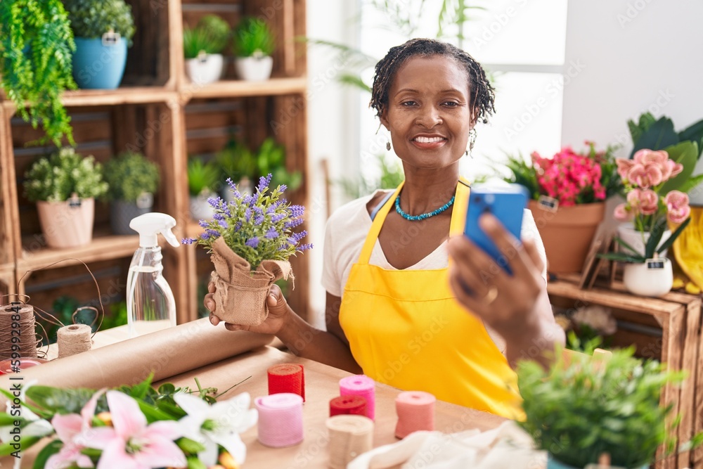 Middle age african american woman florist make selfie by smartphone holding lavender plant at flower shop
