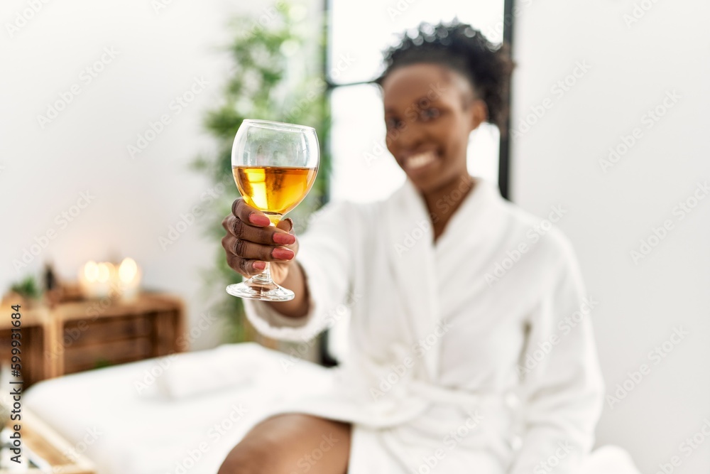 African american woman wearing bathrobe drinking champagne at beauty salon African american woman wearing bathrobe drinking champagne at beauty salon