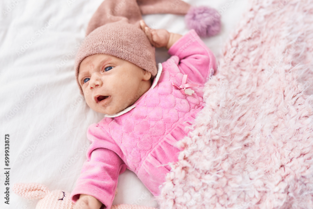 Adorable hispanic baby lying on bed with toy at bedroom Adorable hispanic baby lying on bed with toy at bedroom