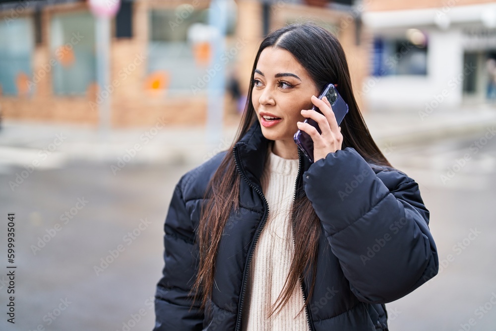 Young beautiful hispanic woman smiling confident talking on smartphone at street Young beautiful hispanic woman smiling confident talking on smartphone at street