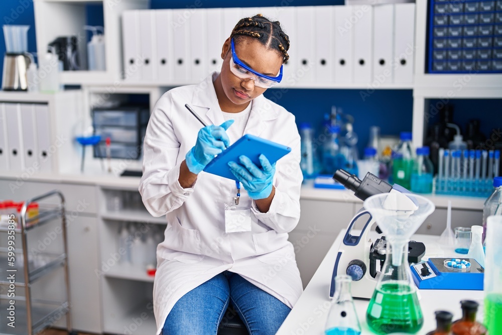 African american woman scientist using touchpad at laboratory African american woman scientist using touchpad at laboratory
